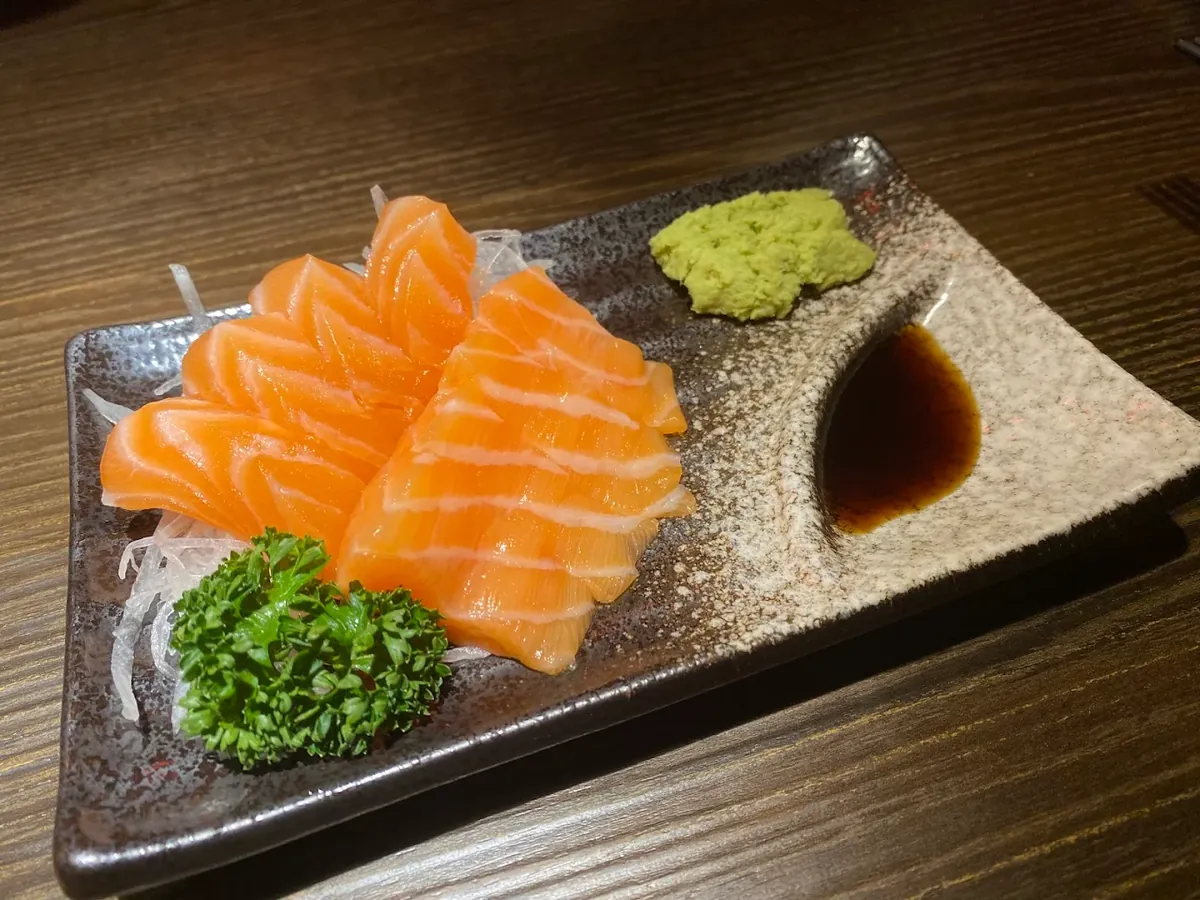 居酒屋的生魚片拼盤，魚肉切面油脂分明，冰涼擺盤是夏天最直覺的開場